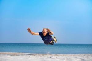 giovane atleta maschio che si allena in una giornata di sole sulla spiaggia foto