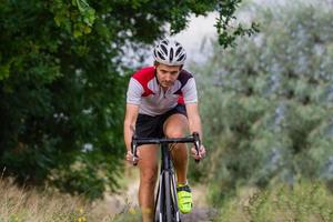 ciclista su bici da ciclocross allenamento all'aperto su strada di campagna sterrata foto