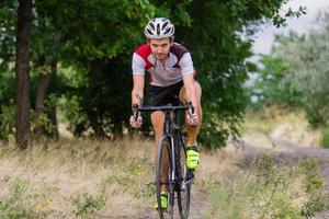 ciclista su bici da ciclocross allenamento all'aperto su strada di campagna sterrata foto