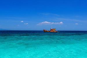 nave traghetto arancione nel mare azzurro, loh moo dee beach, phi phi don, foto