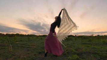 felice danza femminile nei campi estivi durante il bel tramonto foto