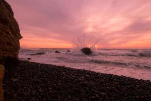 bellissimo paesaggio marino all'alba, cielo colorato rosa e arancione e tempesta nel mare. foto