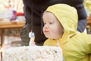 due anni ragazza divertente con torta di compleanno festeggia all'aperto foto