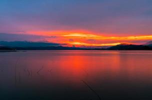 cielo al tramonto rosso e arancione sulla montagna e sul lago. bel cielo serale. maestoso cielo al tramonto. sfondo della natura. foto