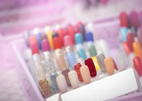 unghie artificiali colorate nel negozio del salone di bellezza. set di unghie finte per consentire al cliente di scegliere il colore per manicure o pedicure nel salone di bellezza e nel negozio termale. nail art e design. esempio di tavolozza di smalti per unghie. foto