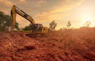 terne che lavorano scavando terreno in cantiere. denti della benna del terreno di scavo dell'escavatore a cucchiaia rovescia. escavatore che scava sulla terra. macchina da scavo. macchina movimento terra. retroescavatore per background aziendale di noleggio. foto