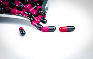capsule rosa-nere sul vassoio del farmaco. resistenza ai farmaci agli antibiotici. assistenza sanitaria globale. capsule antimicrobiche. sfondo della farmacia. uso di farmaci antibiotici con ragionevole. industria farmaceutica. foto