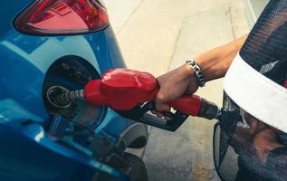 rifornimento auto alla stazione di servizio. fare rifornimento fare il pieno di benzina benzina. ugello del carburante di riempimento della pompa di benzina nel serbatoio del carburante dell'auto alla stazione di servizio. industria e servizi della benzina. prezzo della benzina e concetto di crisi petrolifera. foto