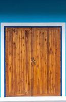 porta di legno sporca e parete blu. foto