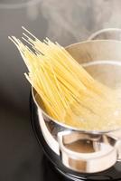 padella con steamin di cottura degli spaghetti foto