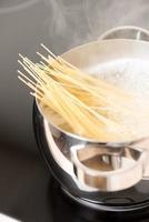 padella con spaghetti cottura verticale foto