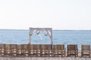 impostazione di cerimonia nuziale in legno sulla spiaggia foto
