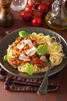 spaghetti italiani della pasta bolognese con basilico sulla tavola rustica foto