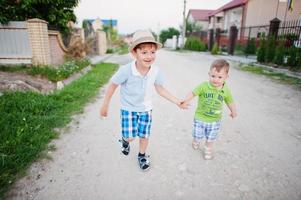 due fratelli che camminano tenendosi per mano, amore fratello. foto