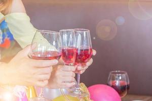 amici felici che tostano un bicchiere di vino mentre mangiano al ristorante, gruppo di persone che cenano concetto foto