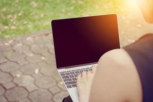 primo piano di donne d'affari che lavorano con il computer portatile nel parco. foto