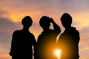 concetto di successo e lavoro di squadra, silhouette di ingegnere e squadra di lavoratori con tracciato di ritaglio in piedi con sfondo tramonto foto