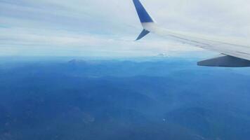 aereo che vola con montagne e paesaggio e nuvole foto