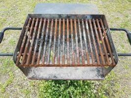 barre di metallo arrugginite marroni sulla griglia del barbecue con fuliggine e un foro foto