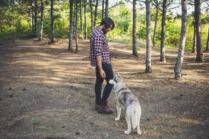 giovane viaggiatore maschio con cane husky foto