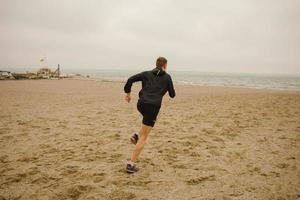 corridore che si allena in una giornata di sole, sullo sfondo del mare foto