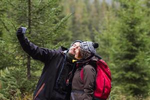 giovani coppie di escursionisti con tazze thermos nella foresta, viaggiatori in montagna che bevono tè o caffè foto