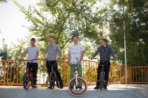 gruppo di giovani con biciclette bmx in skate plaza, ciclisti acrobatici nello skatepark foto