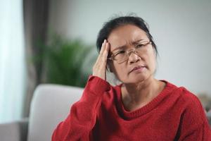 esausto stanco depresso stressato premuroso maturo donna anziana che soffre di mal di testa, malattie del cervello, problemi mentali, concetto di alzheimer. foto