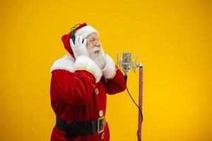 Babbo Natale che canta o parla in un microfono da studio. buon Natale. emittente. annunciatore. promozione. concetto di musica di natale. foto