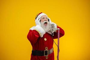 Babbo Natale che canta o parla in un microfono da studio. buon Natale. emittente. annunciatore. promozione. concetto di musica di natale. foto