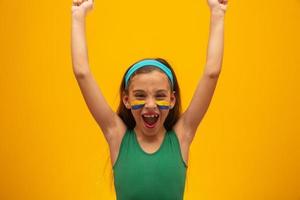 tifoso di calcio, squadra del Brasile. Coppa del Mondo. bella bambina tifo per la sua squadra su sfondo giallo foto