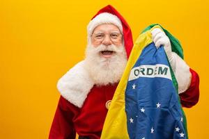 Babbo Natale è un fan del Brasile. tifoso di babbo natale della squadra brasiliana. campionato sportivo. Babbo Natale che tiene la bandiera brasiliana. partita di calcio. foto