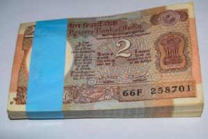 vecchie banconote da due rupie combinate sul tavolo, denaro indiano sul tavolo rotante. vecchie banconote in valuta indiana su una tavola rotante, valuta indiana sul tavolo foto