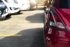 lato posteriore del parcheggio auto rossa sulla strada prepararsi per la gara o il parcheggio. temporaneamente bloccato nel percorso, immagini sfocate delle auto parcheggiate nel parcheggio. foto