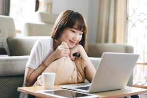 donna asiatica dell'adolescente che impara tramite la videoconferenza del Internet con il computer portatile. foto