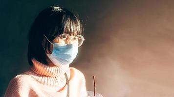 giovane donna asiatica con occhiali da vista indossa una maschera per proteggere il virus corona o covid19 con sfondo e spazio per la copia. foto