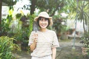 felice giovane donna asiatica adulta nel giardino di casa il giorno. foto