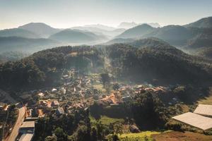 vista aerea del villaggio tradizionale della tribù nella nebbia tra la valle e lo strato montuoso al mattino foto