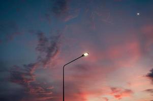 palo della luce stradale con la luna e il cielo serale foto