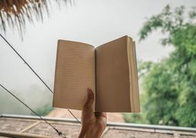 mano della donna che tiene pagina vuota del libro foto