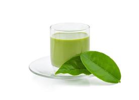 tè verde caldo matcha latte con tè verde in polvere e foglie di tè isolate su sfondo bianco. foto