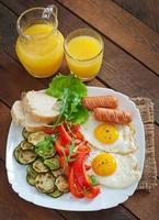 colazione inglese - uova fritte, salsicce, zucchine e peperoni dolci