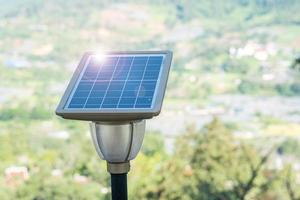 piccoli pannelli solari fotovoltaici con lampada luminosa in foresta, impianti di produzione di energia elettrica. concetto di energia alternativa, rinnovabile e risorse sostenibili foto