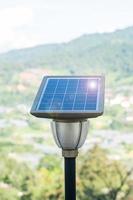 piccoli pannelli solari fotovoltaici con lampada luminosa in foresta, impianti di produzione di energia elettrica. concetto di energia alternativa, rinnovabile e risorse sostenibili foto