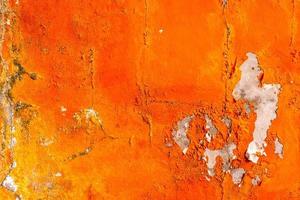 il colore arancione dipinto sul muro di cemento si sta staccando. vecchio e sporco muro texture di sfondo con spazio. foto