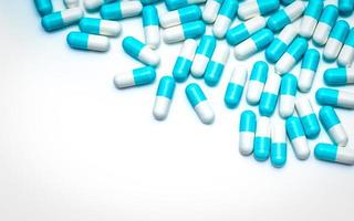 pillole di capsule antibiotiche blu-bianche su sfondo bianco. pillole colorate per l'argomento sanitario. industria farmaceutica. concetto di resistenza ai farmaci antibiotici. farmaco antimicrobico. farmaceutici. foto