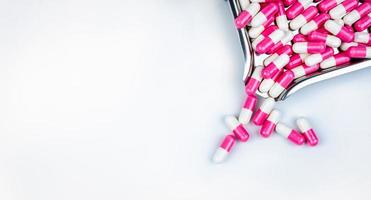 vista dall'alto delle capsule rosa-bianche sul vassoio del farmaco. farmaco antipsicotico. capsule medicinali per il trattamento della depressione. farmaco ansiogeno. assistenza sanitaria globale. sfondo della farmacia. industria farmaceutica. foto