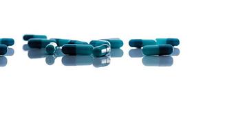 messa a fuoco selettiva sulle capsule blu. gruppo di capsule pillole con ombra diffusa su sfondo bianco. prodotto della farmacia della farmacia. background sanitario e assicurativo. industria farmaceutica. foto