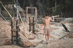 i bambini poveri del cantiere sono stati costretti a lavorare. concetto contro il lavoro minorile. l'oppressione o l'intimidazione del lavoro forzato tra i bambini. tratta di esseri umani. foto