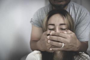 gli uomini usano le mani per coprirsi la bocca, le donne non hanno modo di combattere. problemi familiari, violenza domestica, stop alla violenza e alle molestie, tratta di esseri umani, stupri, aggressioni, coercizione. foto